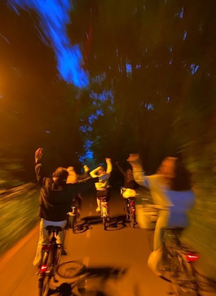 Friends riding bicycles together at night